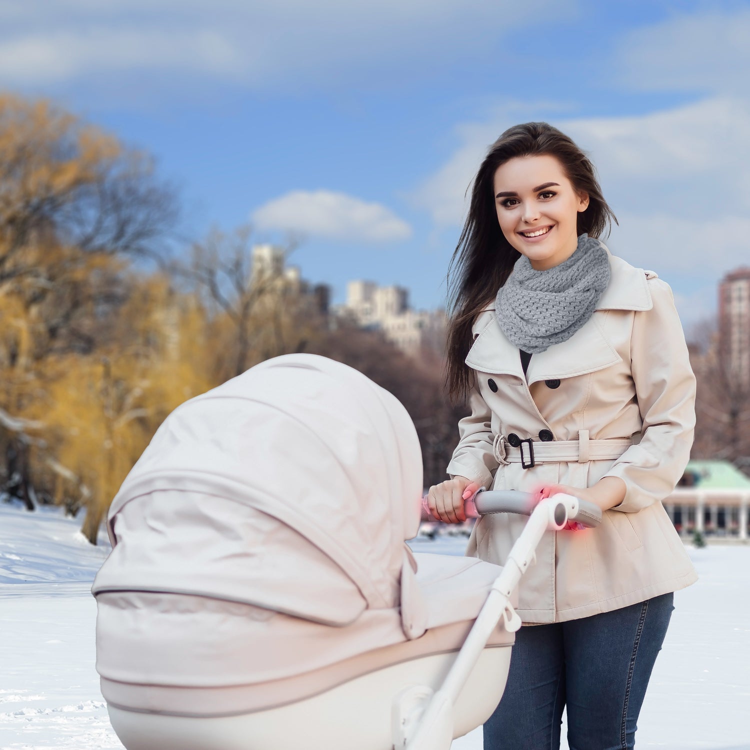 Frau spaziert in der Natur mit Handwärmer Kinderwagen und Taschenwärmer